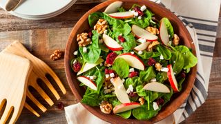Apple and walnut salad in wooden bowl