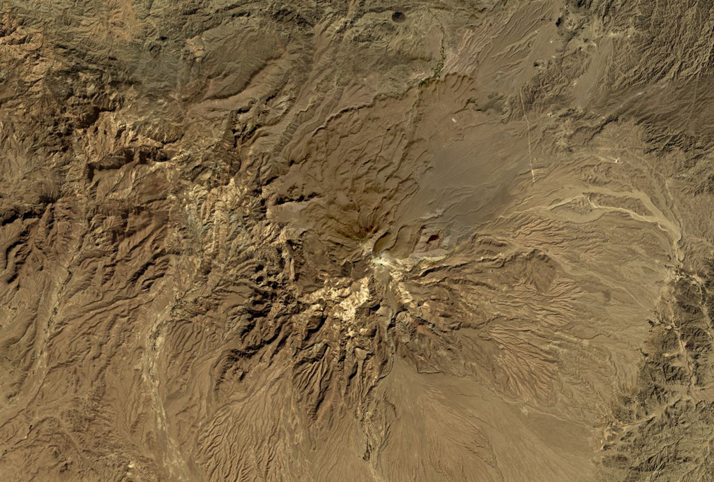 A satellite view of a brown peak of a volcano.