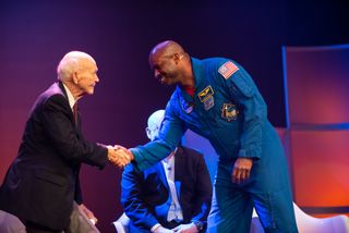 Astronaut Leland Melvin (right) greets Apollo 11 command module pilot Michael Collins onstage during a World Science Festival event held May 31, 2019.