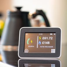 Smart energy meter on a kitchen worktop with a black and copper kettle in the background