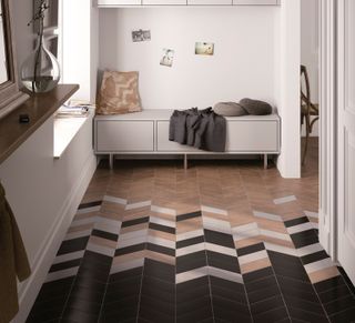 Chevron floor tiles in a hallway with a storage bench