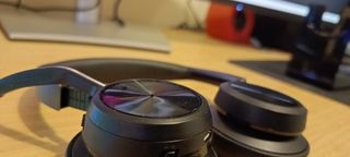 A pair of Poly Voyager Focus 2 headphones on a wooden desk