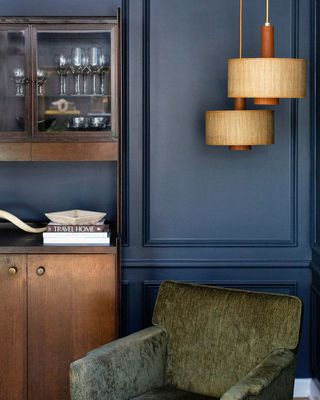 Navy blue wall in living room with olive green chair