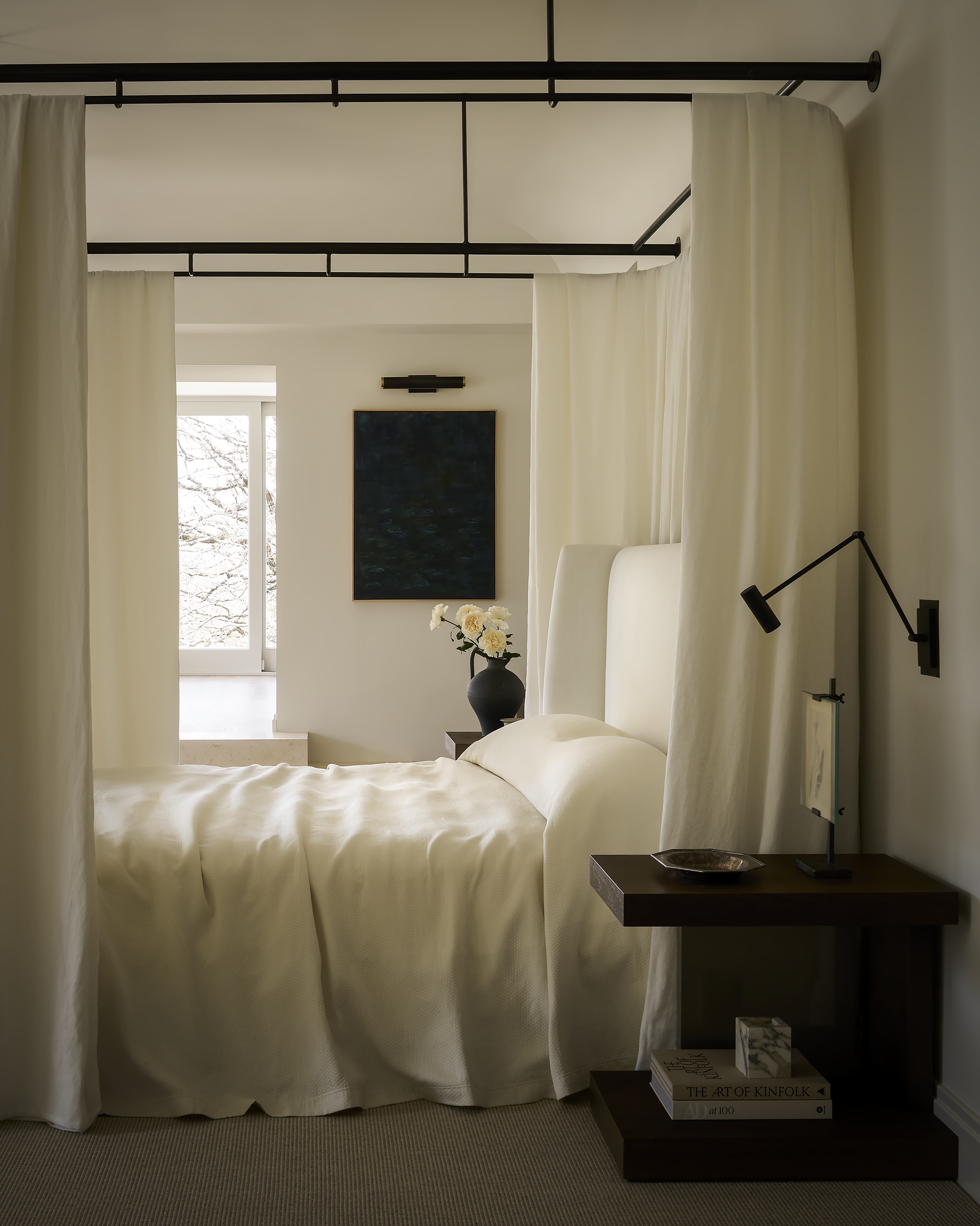 a modern white bedroom with a bed with drapes