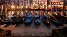 Gondolas are seen tied up in Venice Canal Grande, near Rialto bridge, on January 31, 2018, as exceptionally low tides have drained the lagoon city.The unusually low tides caused a record low 