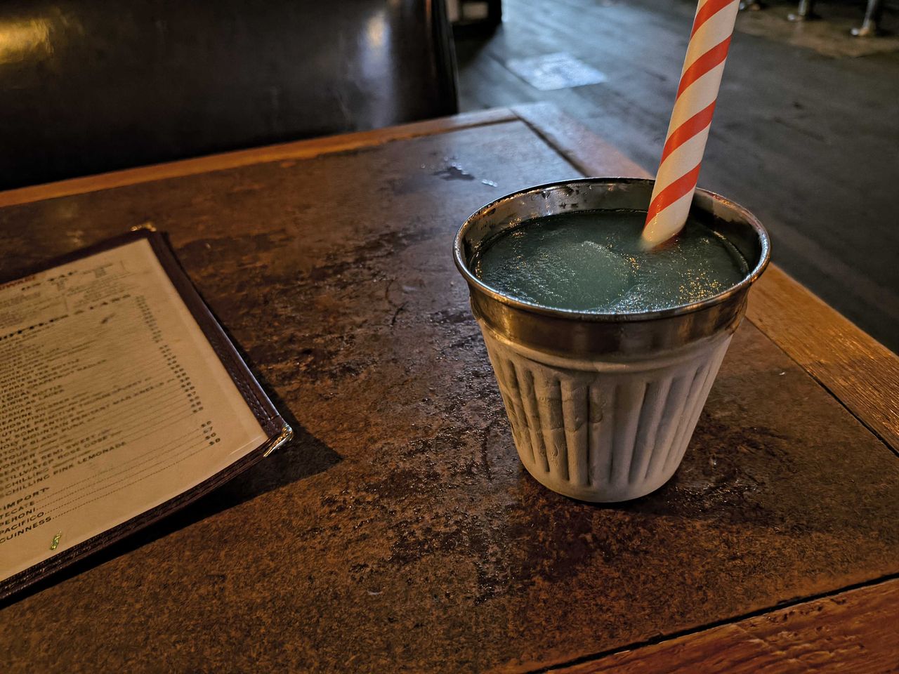 A cup with a slushie and striped straw
