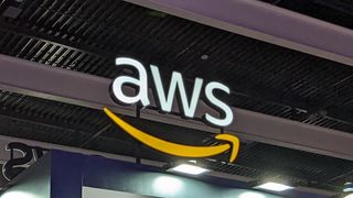 A telephoto shot of the AWS logo on a conference floor, hanging from a beam