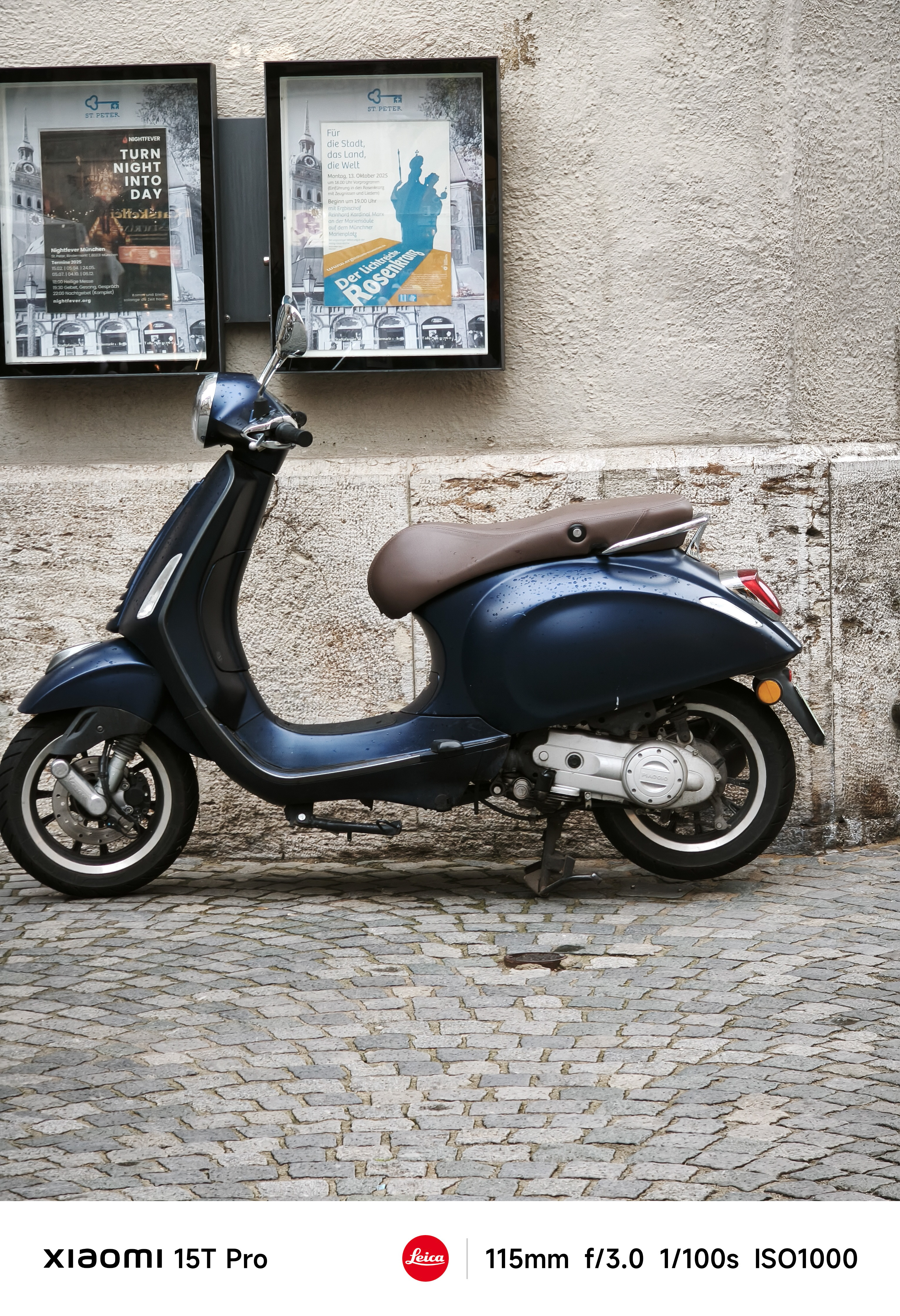 A vesper parked up against a wall on a cobble street