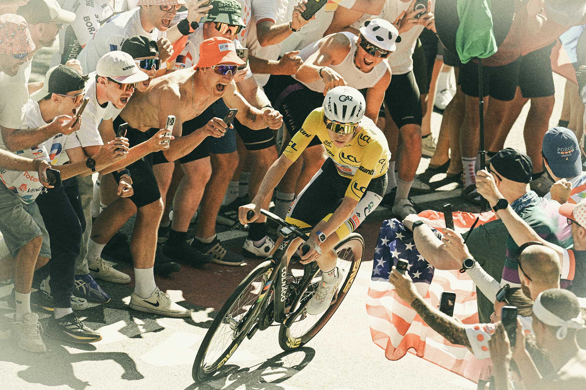 Tadej Pogacar climbing Alpe d'Huez (1835m) while fans cheer during stage 19 of the 113th Tour de France (Photo by Dario Belingheri/Getty Images)