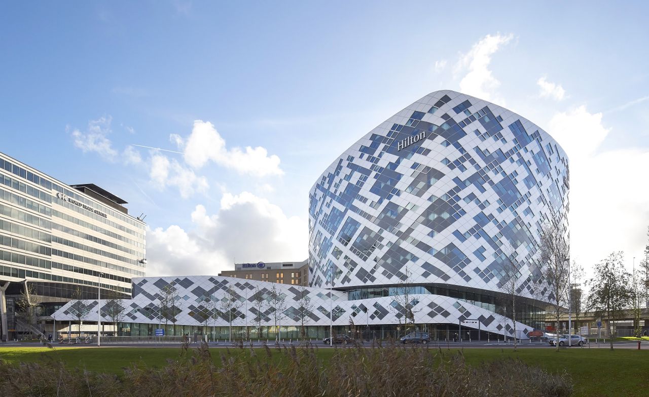 Exterior of the hotel displaying the brand name on a background of white and glass tiles, giving a pixelated look