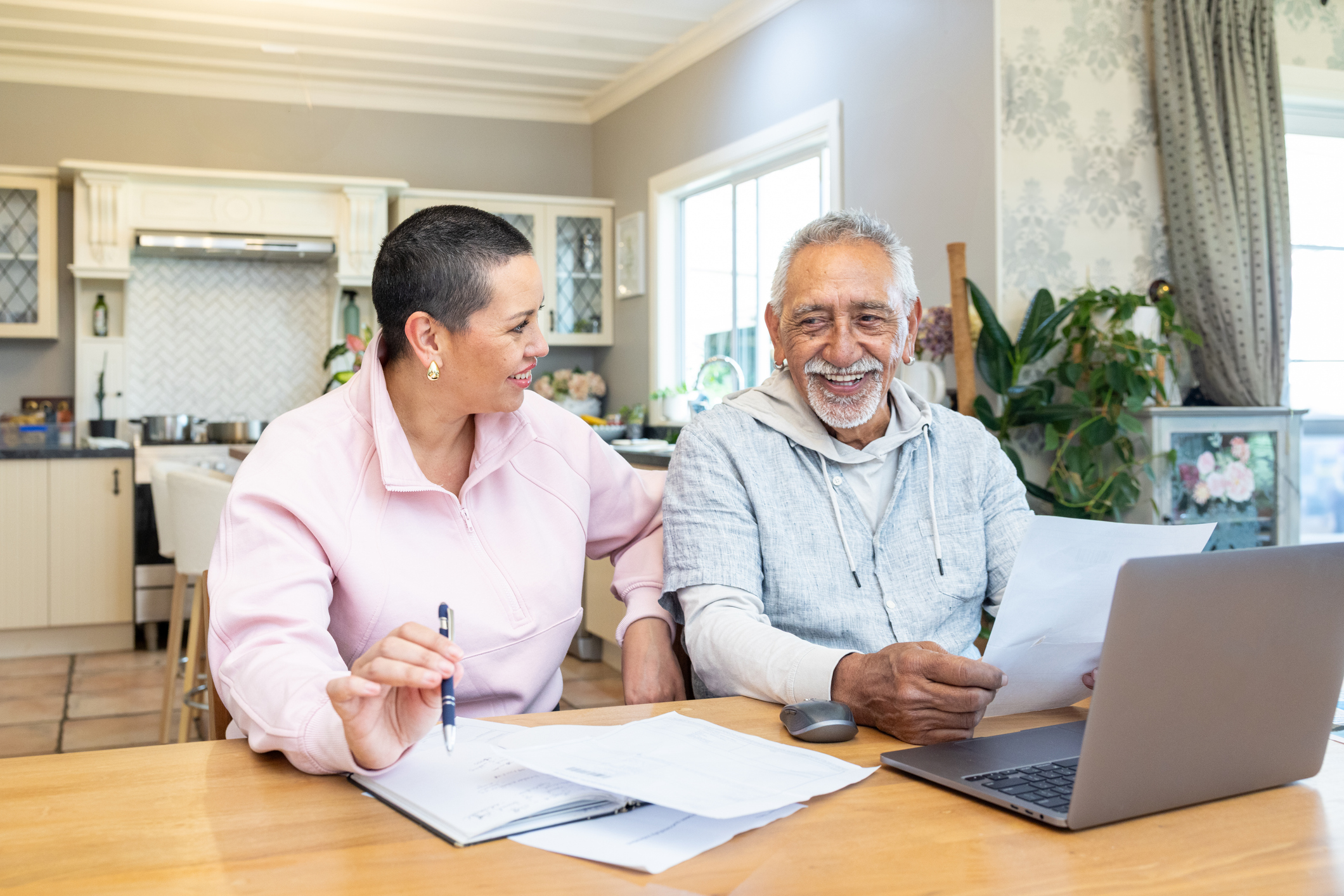 A couple in front of a laptop managing their pension investments