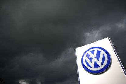A Volkswagen symbol under looming clouds