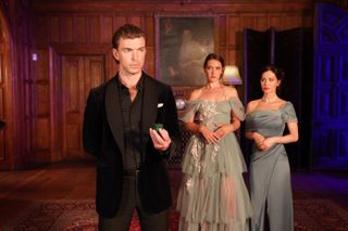 Rafe holding an engagement ring as Sienna and Camilla look on.