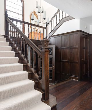 A grand wooden stairway leading up to a white landing