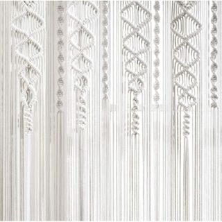 A square with white macrame curtain panels with four diamond woven line patterns