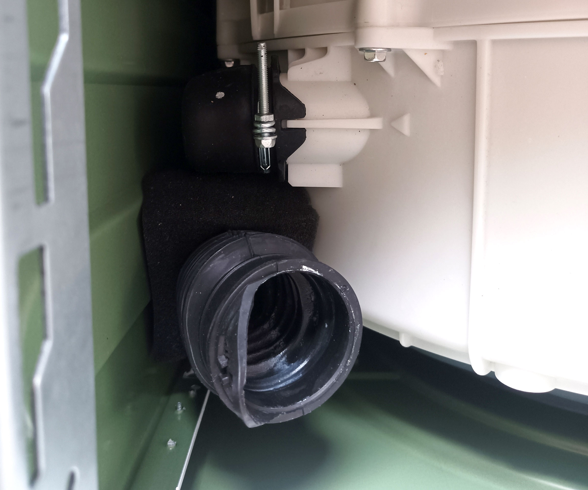 Top down shot of top of washing dispenser hose detached from detergent tray
