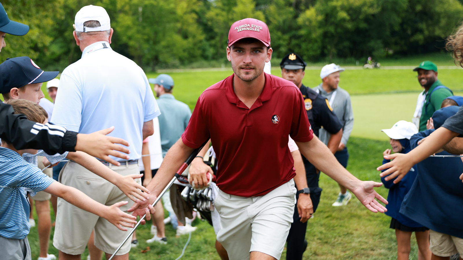 Jack Whaley high fives fans as he walks off the green
