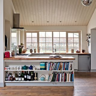 kitchen area with wooden floor and wooden counter with book shelves