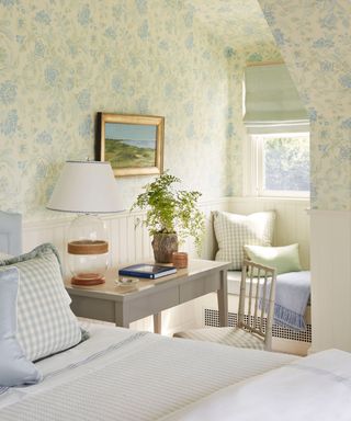 bedroom with blue floral wallpaper and window seat in dormer