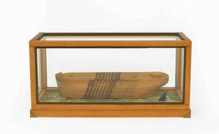 Wooden art piece in a glass and wood display case, white background