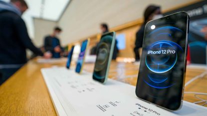 Apple iPhone 12 Pros are shown in an Apple store.