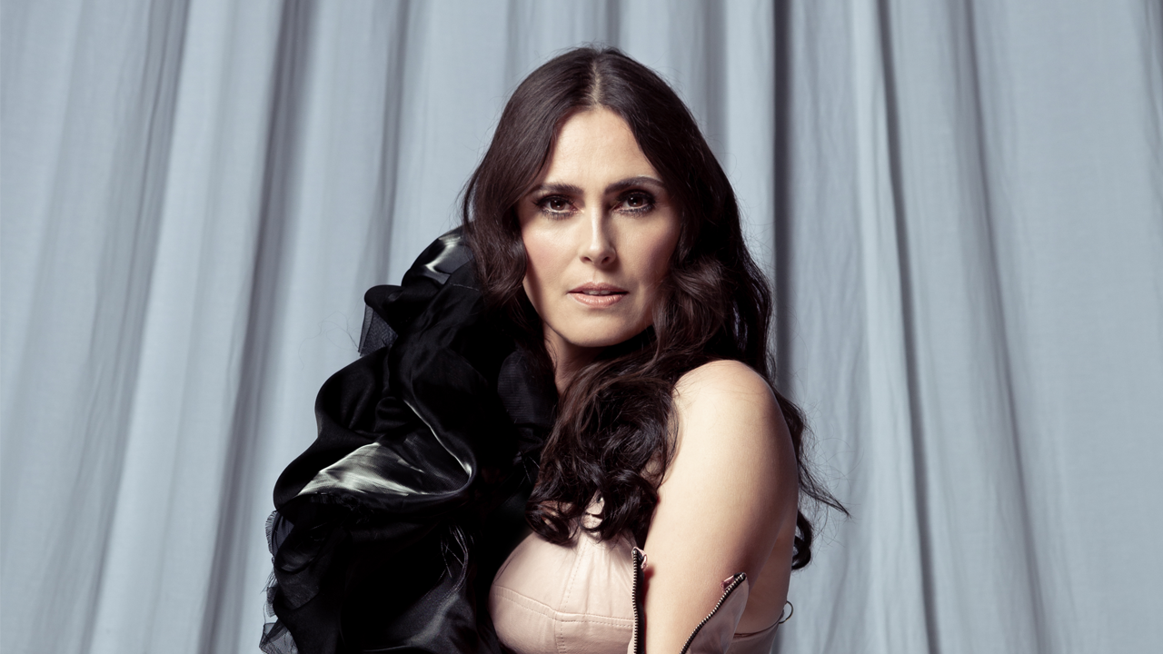 Sharon den Adel in a skin coloured dress