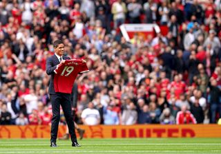 Manchester United’s Raphael Varane holds up his shirt on the pitch