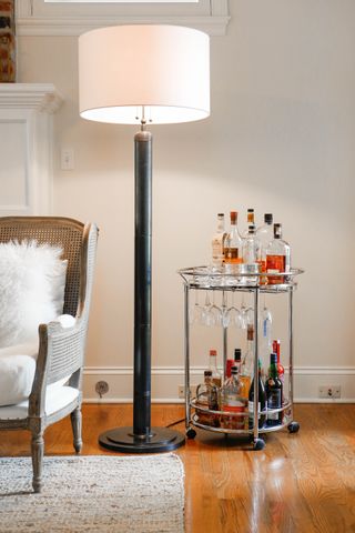 A living room with a small, sleek bar cart
