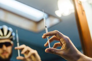 a cyclist holds up a syringe