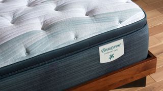 Image shows a corner of the Beautyrest Harmony Lux placed on a wooden bed frame