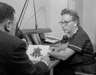 A psychologist at a mental hospital in 1955 discusses a patient's interpretation of an inkblot in the Rorschach test.