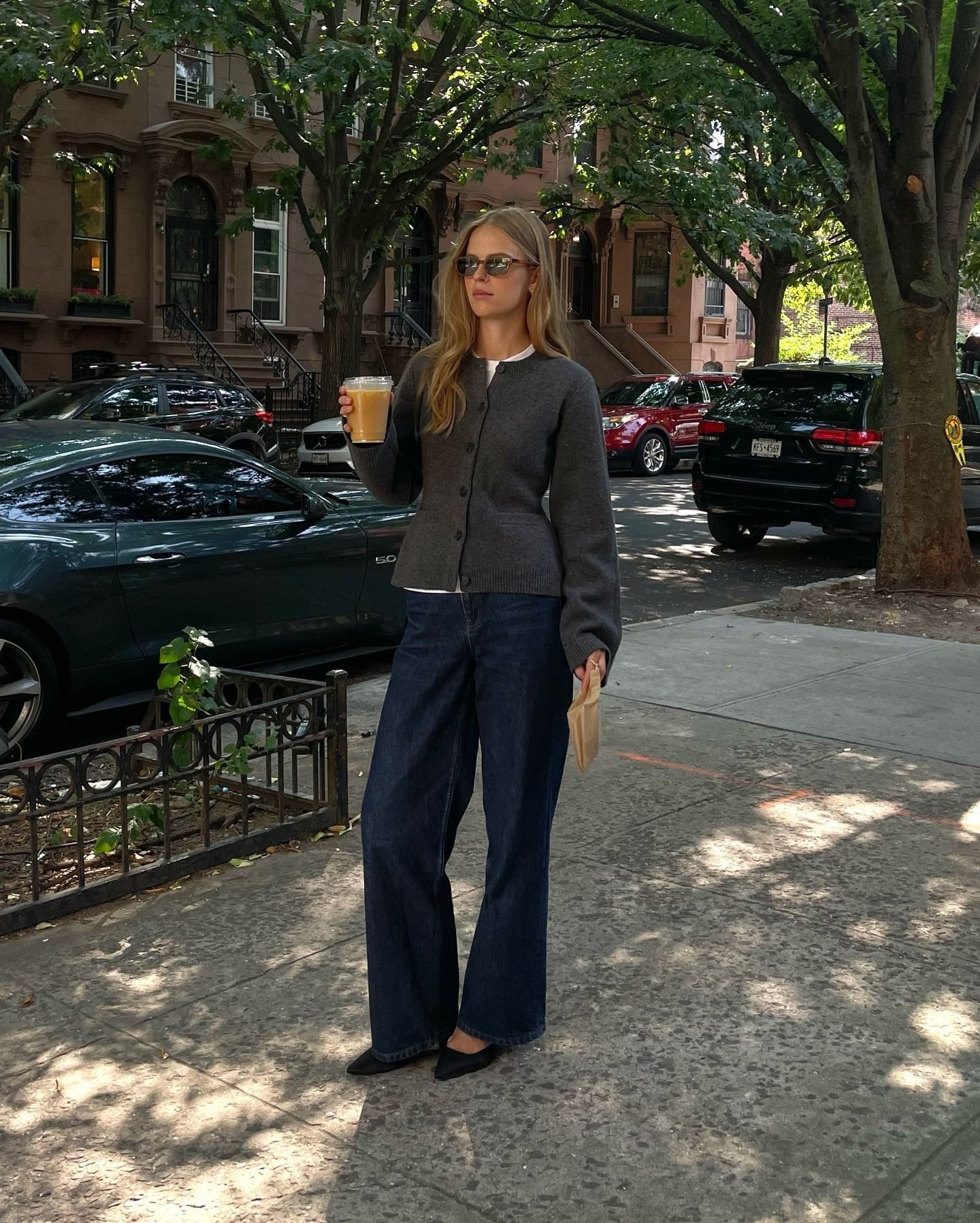 Clara Dyhauage wears a wide-leg dark rinse denim with a cinched heather grey cardigan and flats.
