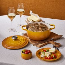 Yellow cast iron pot and dinnerware on table