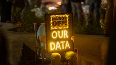 Protesters holds sign against DOGE's efforts to access data of Americans