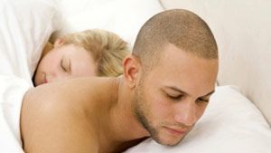 guy using a cell phone while in bed with a woman
