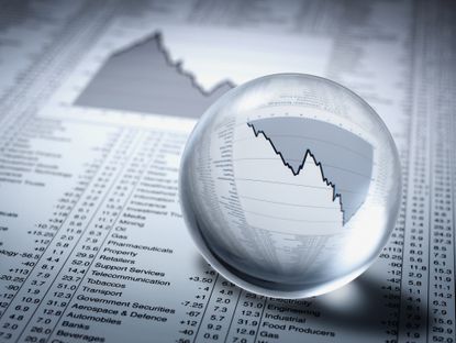 crystal ball over financial charts on newspaper