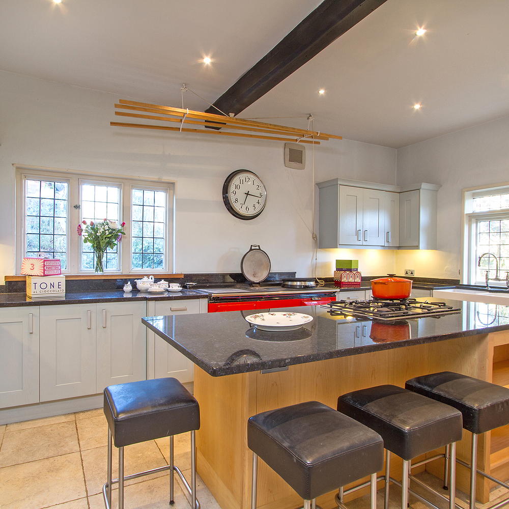 kitchen area with white wall and ceramic worktop and wooden counter with ceramic countertop