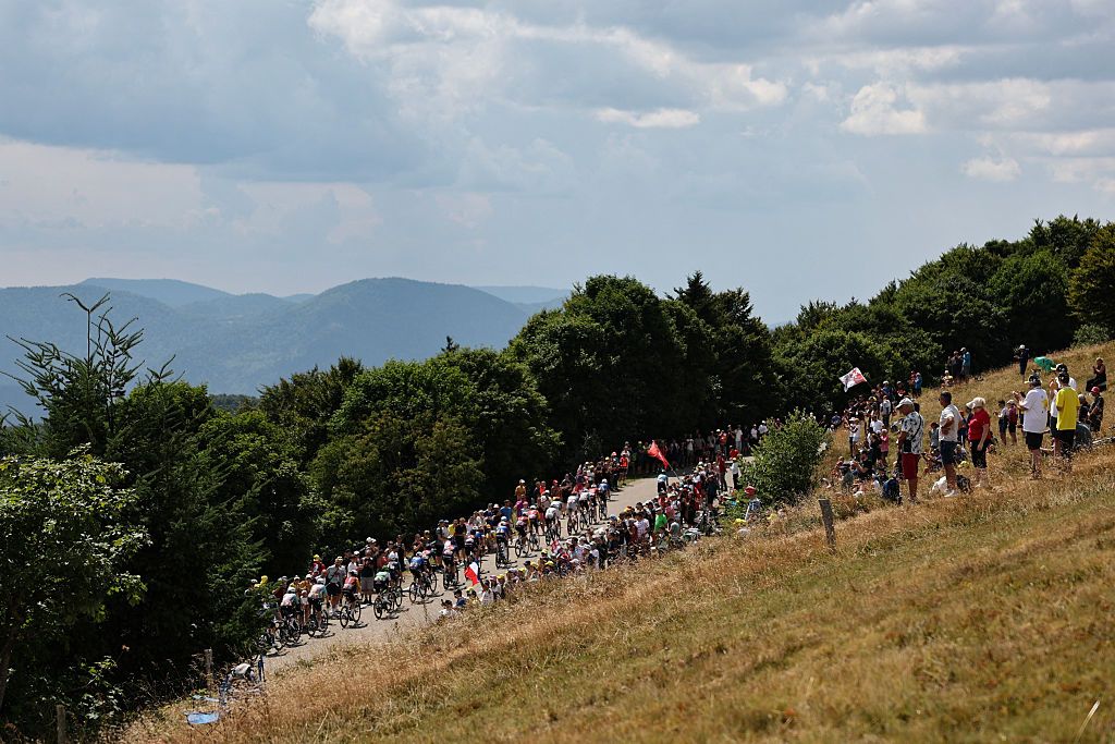 The pack of riders (peloton) completes its first pass of the finish line area before continuing its loop in the Vosges mountains during the 14th stage of the 113th edition of the Tour de France cycling race, 155,3 km between Mulhouse and Le Markstein, on July 18, 2026. (Photo by Anne-Christine POUJOULAT / AFP)