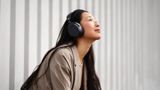 Eine Frau, welche die Sennheiser Momentum 4 Wireless trägt