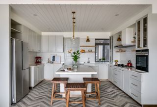 A kitchen with an island with tall stools
