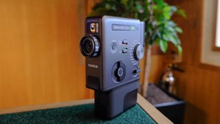 A black Fujifilm Instax mini Evo Cinema hybrid instant camera