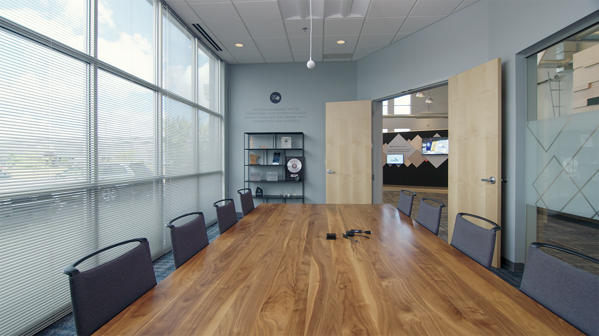 An empty conference room ready for hybrid meetings with a Retractable Universal Mount 4K HDMI Dongle Adapter Ring and C2G cables.