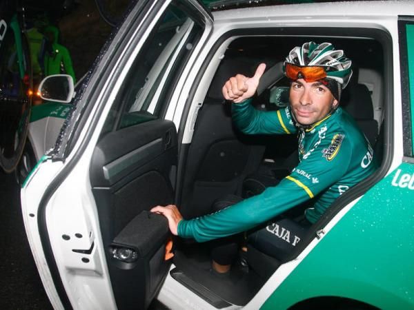 A Europcar rider shelters from the poor conditions after the stage