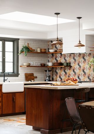 A kitchen with wooden cabinetry and white subway tiles up one wall, and vinyl patterned tiles on the adjacent wall