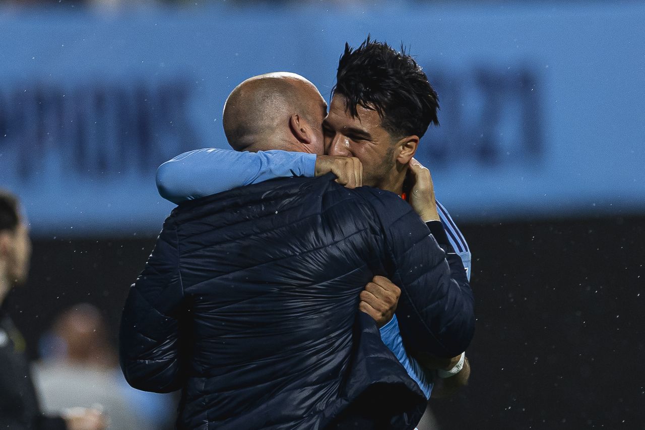 Mounsef Bakrar embraces his manager Nick Cushing on the touchline after scoring for New York City FC
