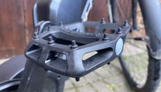 Image shows the DMR V6 flat pedals mounted on a bike