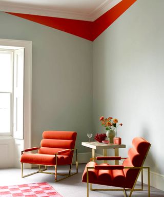 Contemporary orange chairs set against a dune white wall