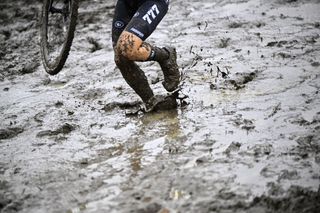 TOPSHOT A competitor walks in the mud carrying her bike during the women elite race of the Koppenbergcross the first race out of eight of the X2O Badkamers trophy cyclocross competition in Melden Oudenaarde on November 1 2023 Photo by JASPER JACOBS Belga AFP Belgium OUT Photo by JASPER JACOBSBelgaAFP via Getty Images