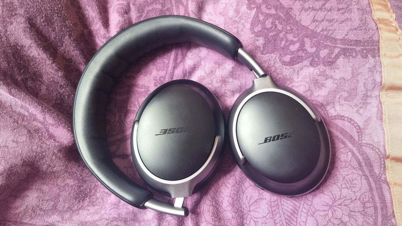 Bose QuietComfort Headphones laid out on a purple pillow