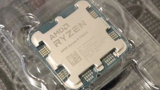 Close-up of an AMD Ryzen 7900X processor in clear packaging, showcasing its metallic surface and circuitry details. The tone is high-tech and sleek.